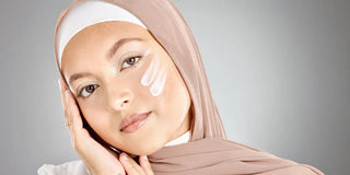 woman with sunscreen swatches on her cheek