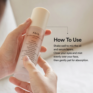 hands holding Abib Jericho Rose Mist Serum Glow Spray bottle