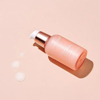 medicube triple collagen serum bottle on a pink surface