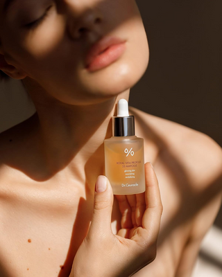 woman holding Dr.Ceuracle Royal Vita Propolis 33 Ampoule bottle