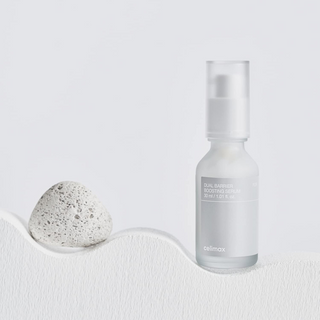a bottle of celimax Dual Barrier Skin Boosting Serum 30mL with a stone on it's right side