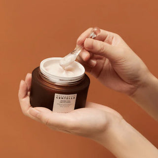 hand holding and scooping out SKIN1004 Probio-Cica Enrich Cream