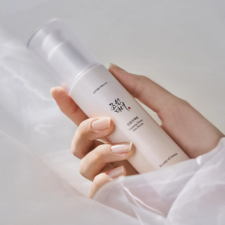 hand holding Ginseng Moist Sun Serum (SPF 50+ PA++++) pump bottle