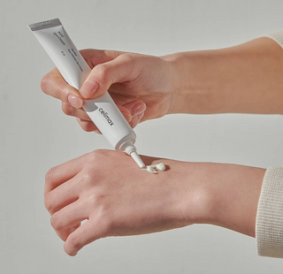 person applying celimax Noni Ultimate Eye Cream onto hand