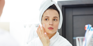 woman applying cream on her face