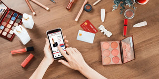hand using mobile with makeup on the surface